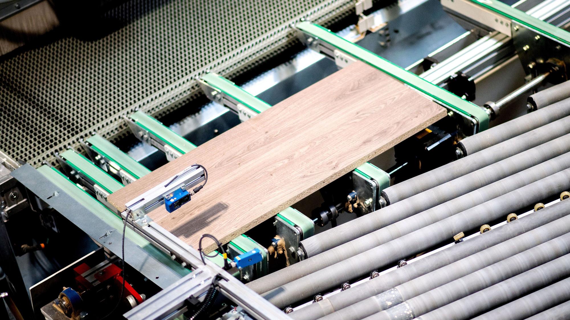 Holzplatten für Tische werden in einem Möbelwerk automatisch zugeschnitten.
