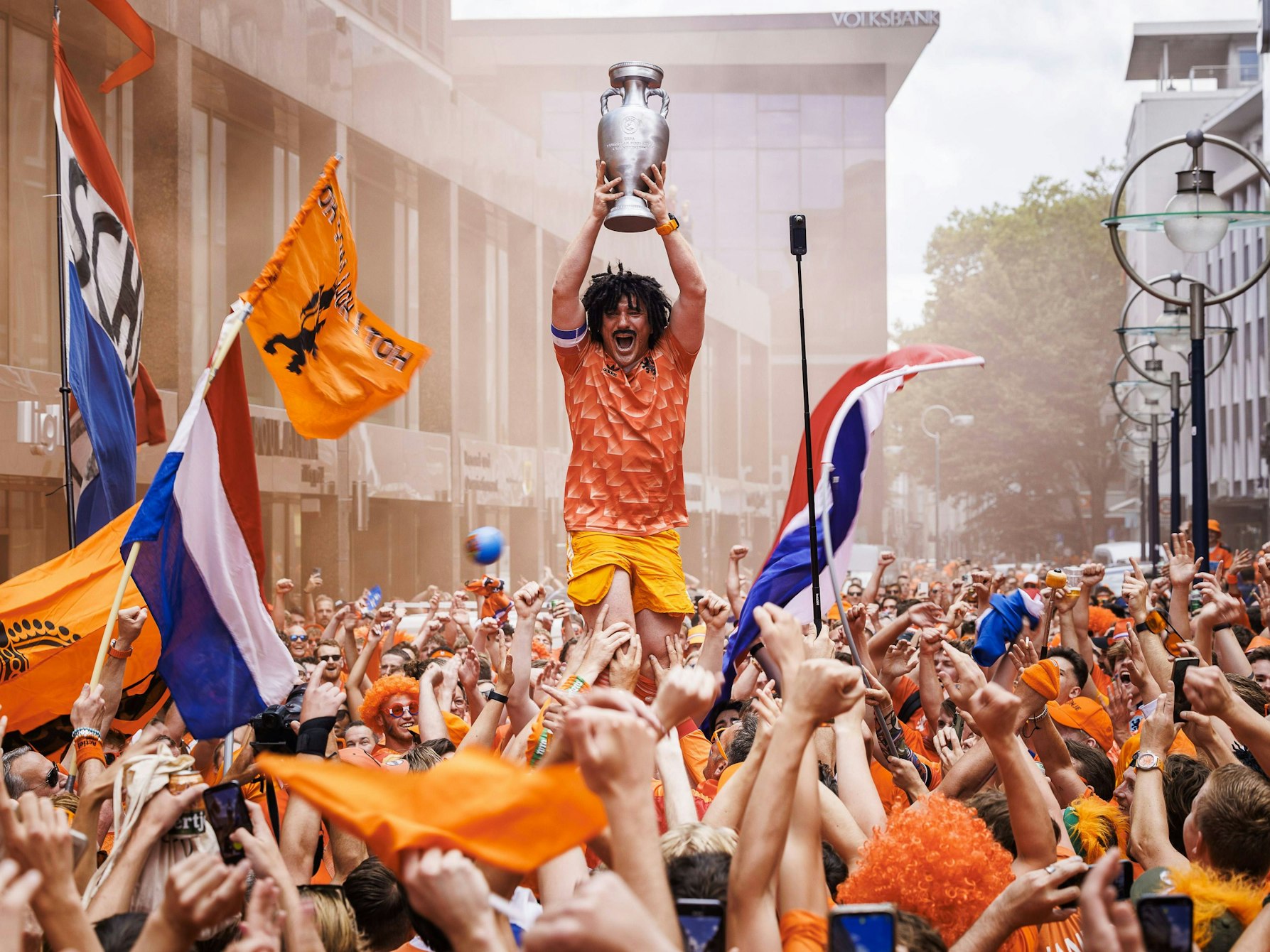 Ein Holland-Fan reckt einen aufblasbaren EM-Pokal in die Höhe.