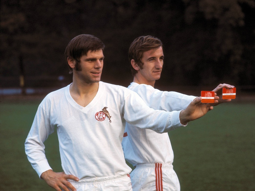 Wolfgang Weber (li.) und Hannes Löhr bei einem Werbeshooting im schneeweißen Heimtrikot des 1. FC Köln.