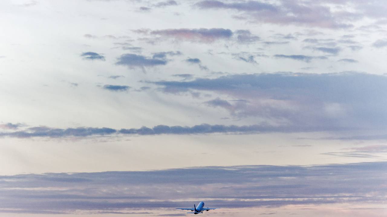 Ein Flugzeug startet vom Flughafen Köln/Bonn in den Morgenhimmel.