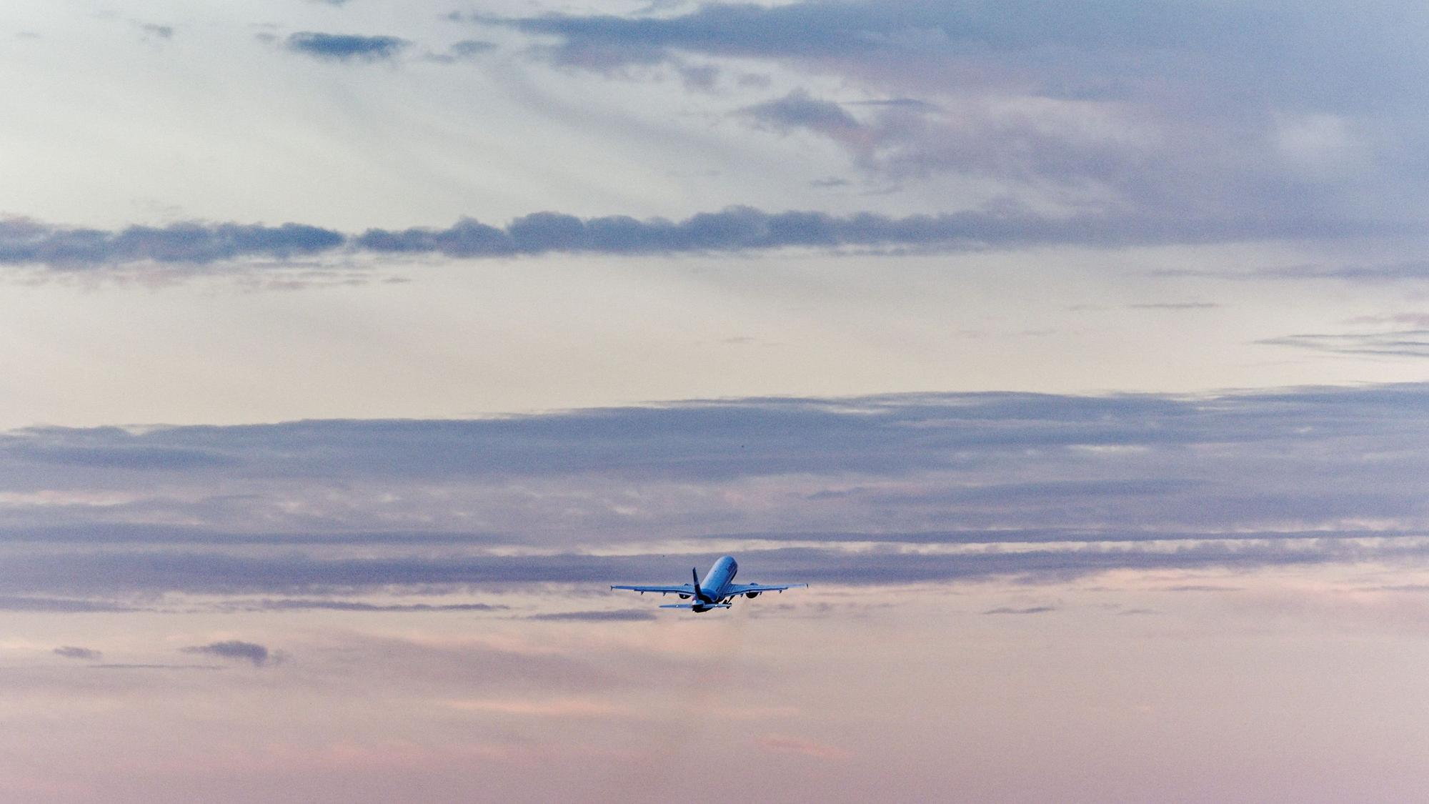 Ein Flugzeug startet vom Flughafen Köln/Bonn in den Morgenhimmel.