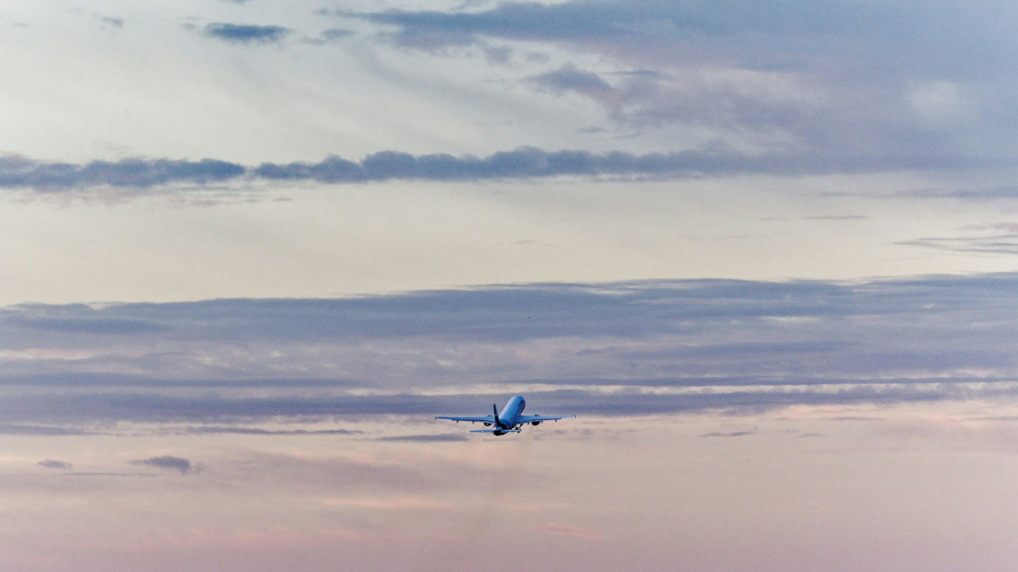 Ein Flugzeug startet vom Flughafen Köln/Bonn in den Morgenhimmel.