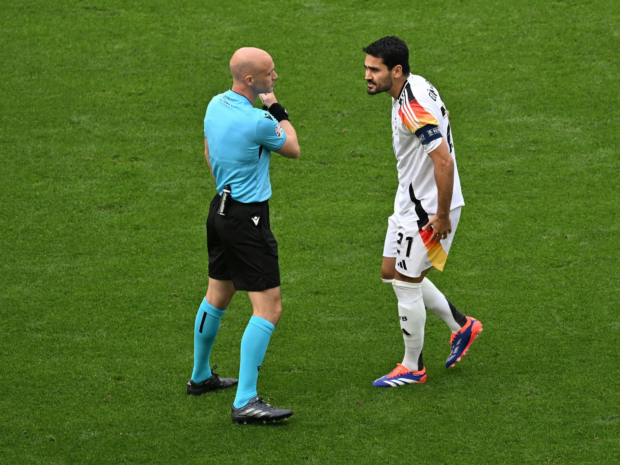 Der Kapitän der deutschen Nationalmannschaft Ilkay Gündogan diskutiert mit dem englischen Schiedsrichter Antony Taylor während des Viertelfinals bei der EM gegen Spanien.