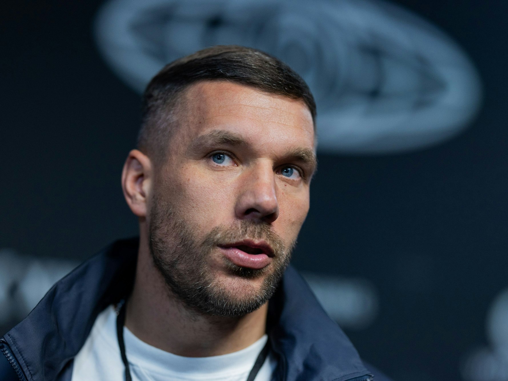 Lukas Podolski, Präsident der „Baller League“, steht neben dem Spielfeld in der Motorworld.