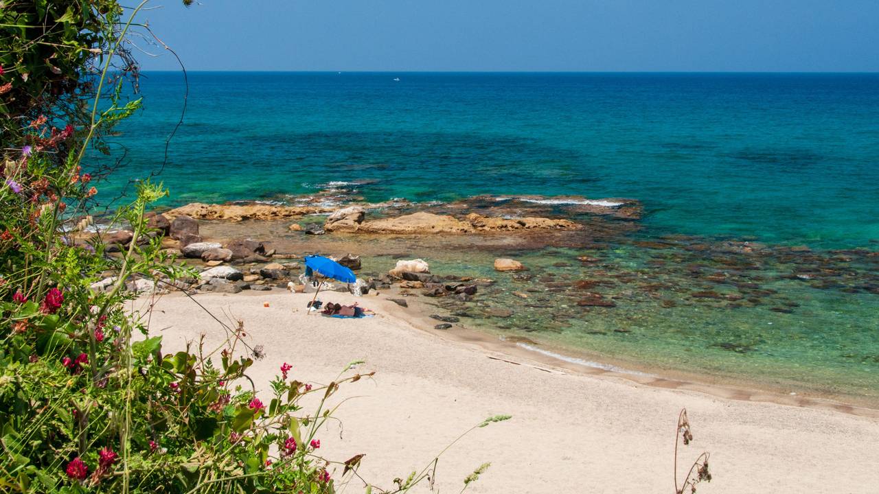 Ein Paar liegt auf Sizilien am Strand.