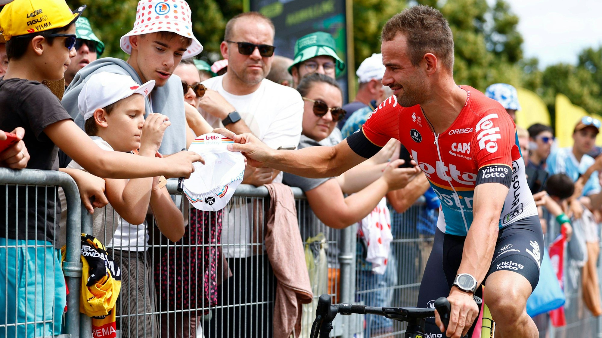 Victor Campenaerts schreibt vor der zwölften Etappe der Tour de France Autogramme.