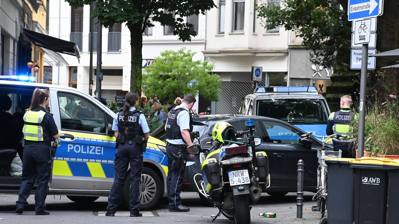 Einsatzkräfte der Polizei stehen mit Streifenwagen und Motorrädern an einer Straßenecke.