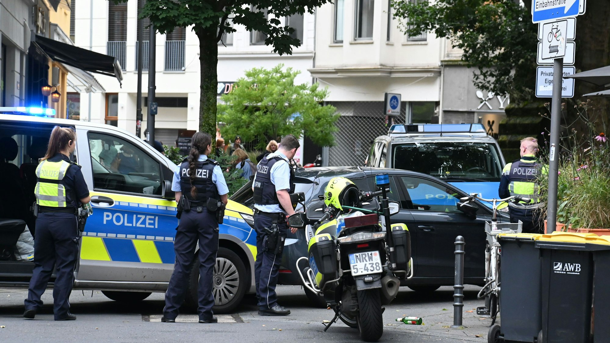 Einsatzkräfte und Einsatzfahrzeuge stehen an einem Pkw.