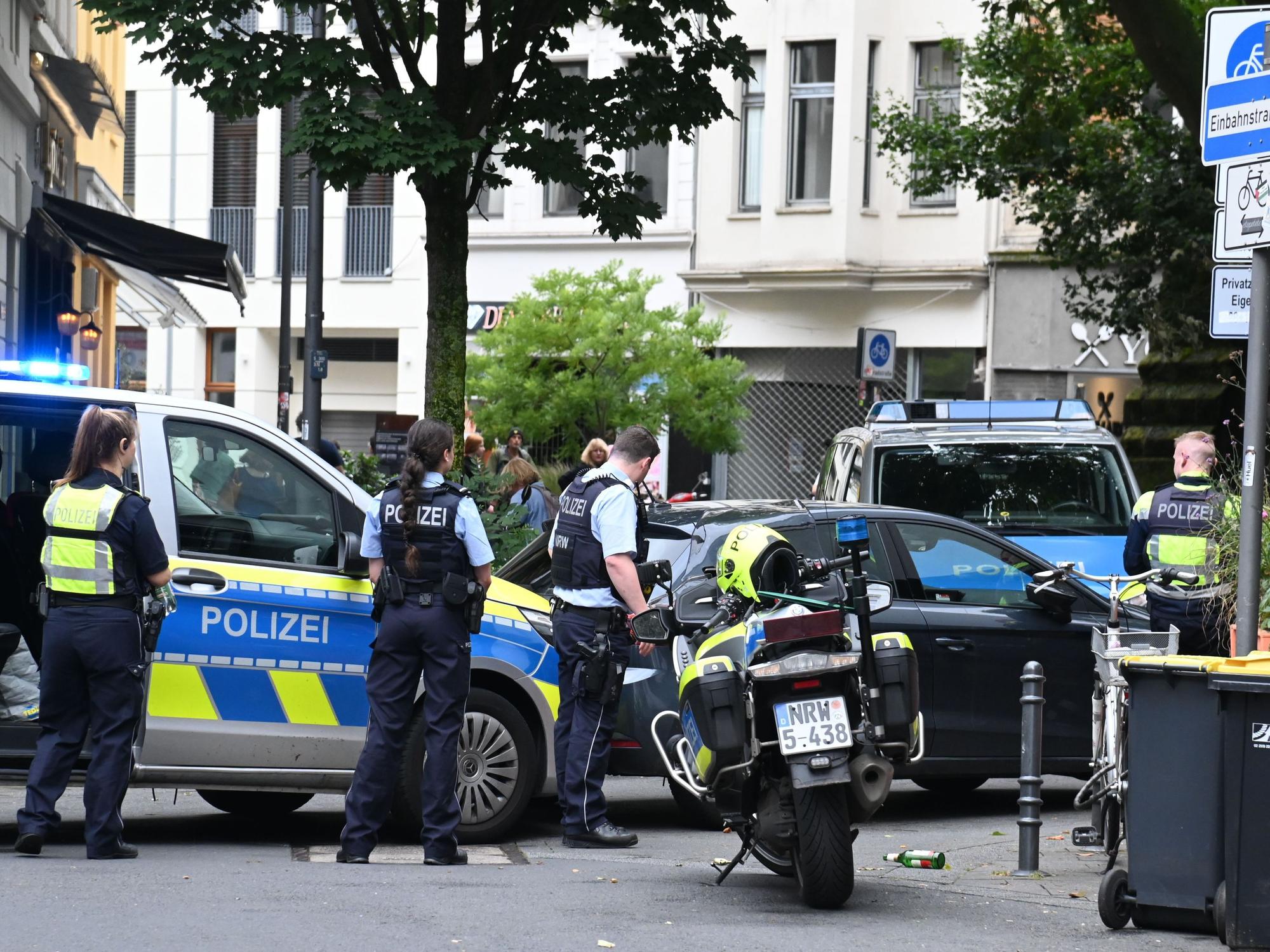 Einsatzkräfte der Polizei stehen in Köln bei einem Einsatz mit Streifenwagen und Motorrädern auf der Straße.