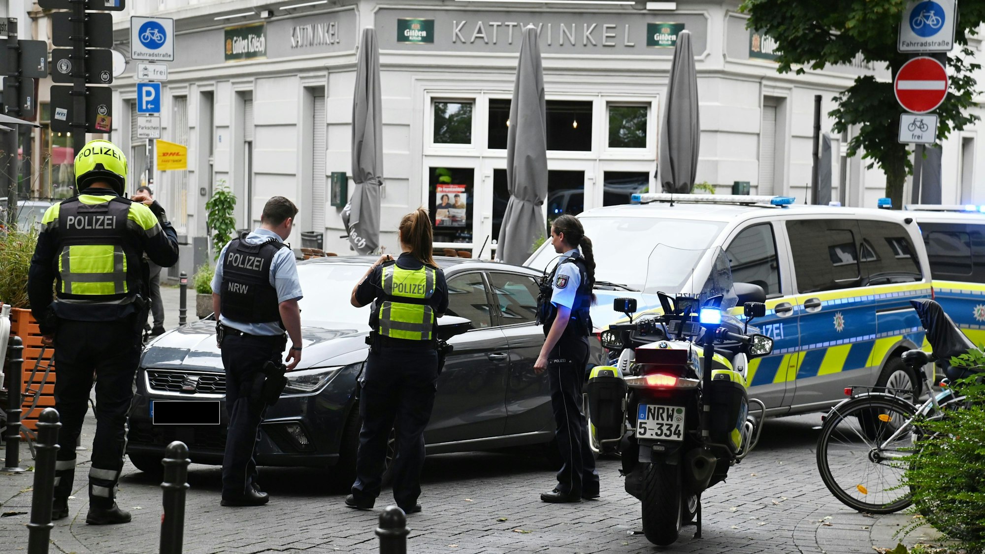 Einsatzkräfte stehen an einem Seat Ibiza am Thürmchenswall Ecke Eigelstein.