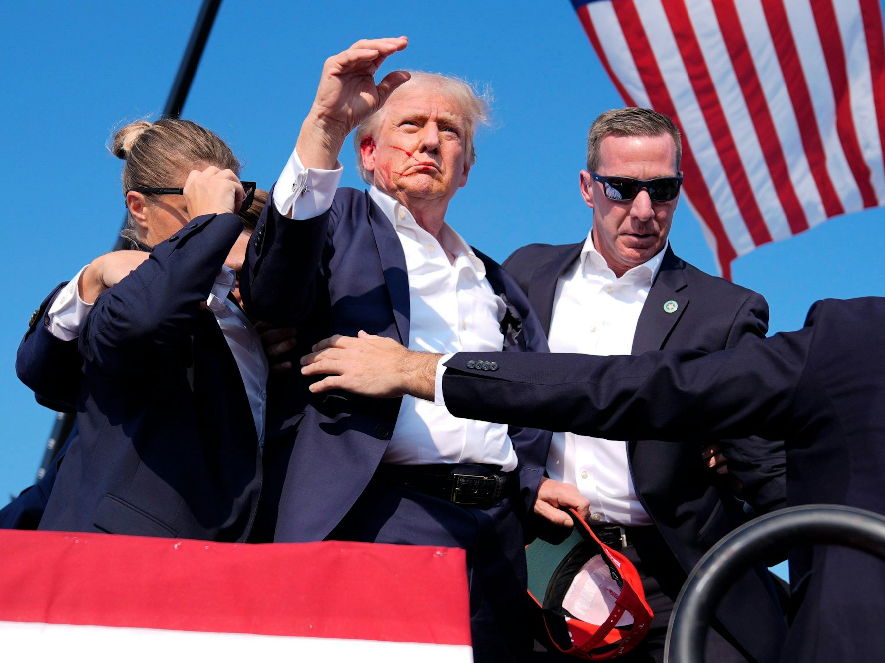Republican presidential candidate former President Donald Trump is surrounded by U.S. Secret Service agents as he leaves the stage at a campaign rally, Saturday, July 13, 2024, in Butler, Pa. (AP Photo/Evan Vucci)