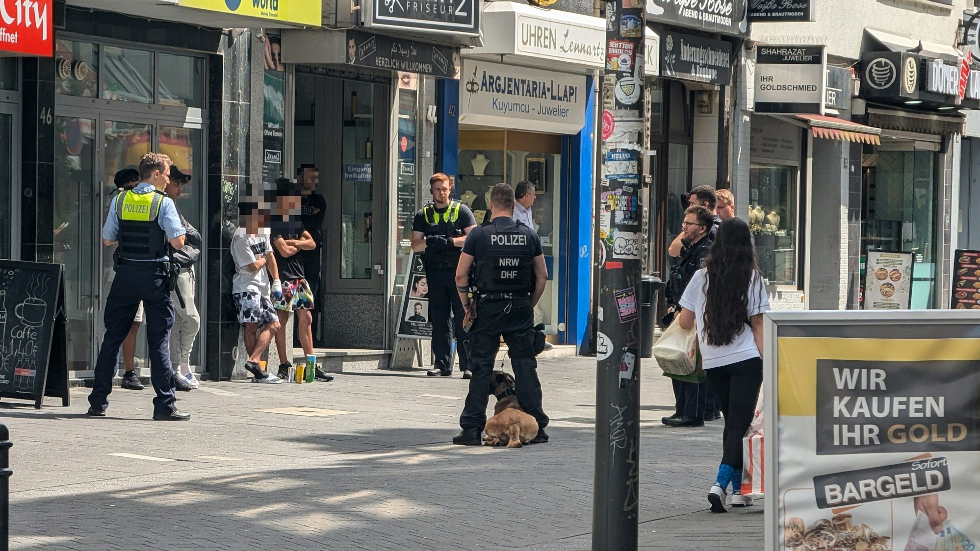 Einsatzkräfte der Polizei stehen um mehreren Verdächtige herum.