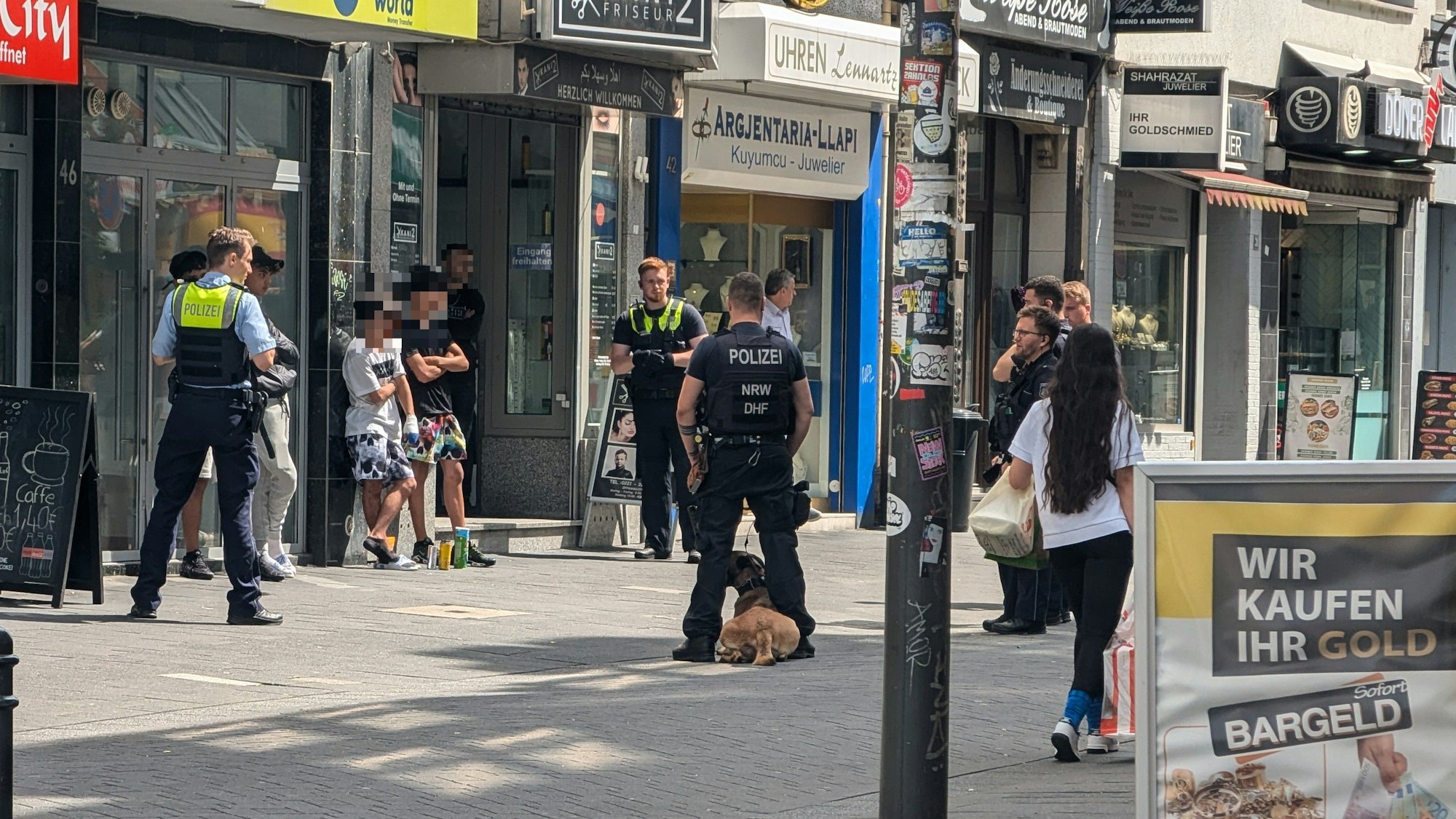 Einsatzkräfte der Polizei stehen um mehreren Verdächtige herum.