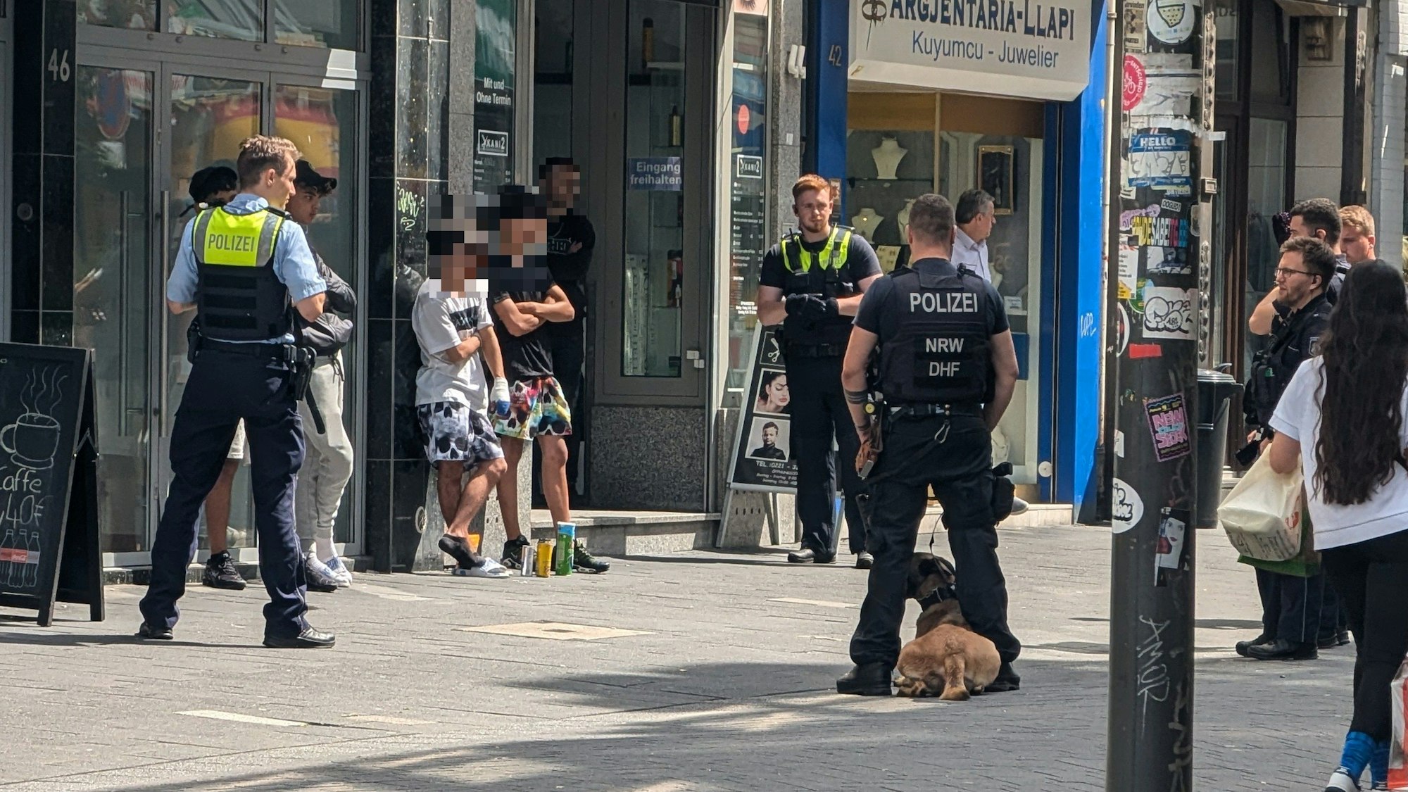 Einsatzkräfte der Polizei stehen um mehreren junge Verdächtige herum.