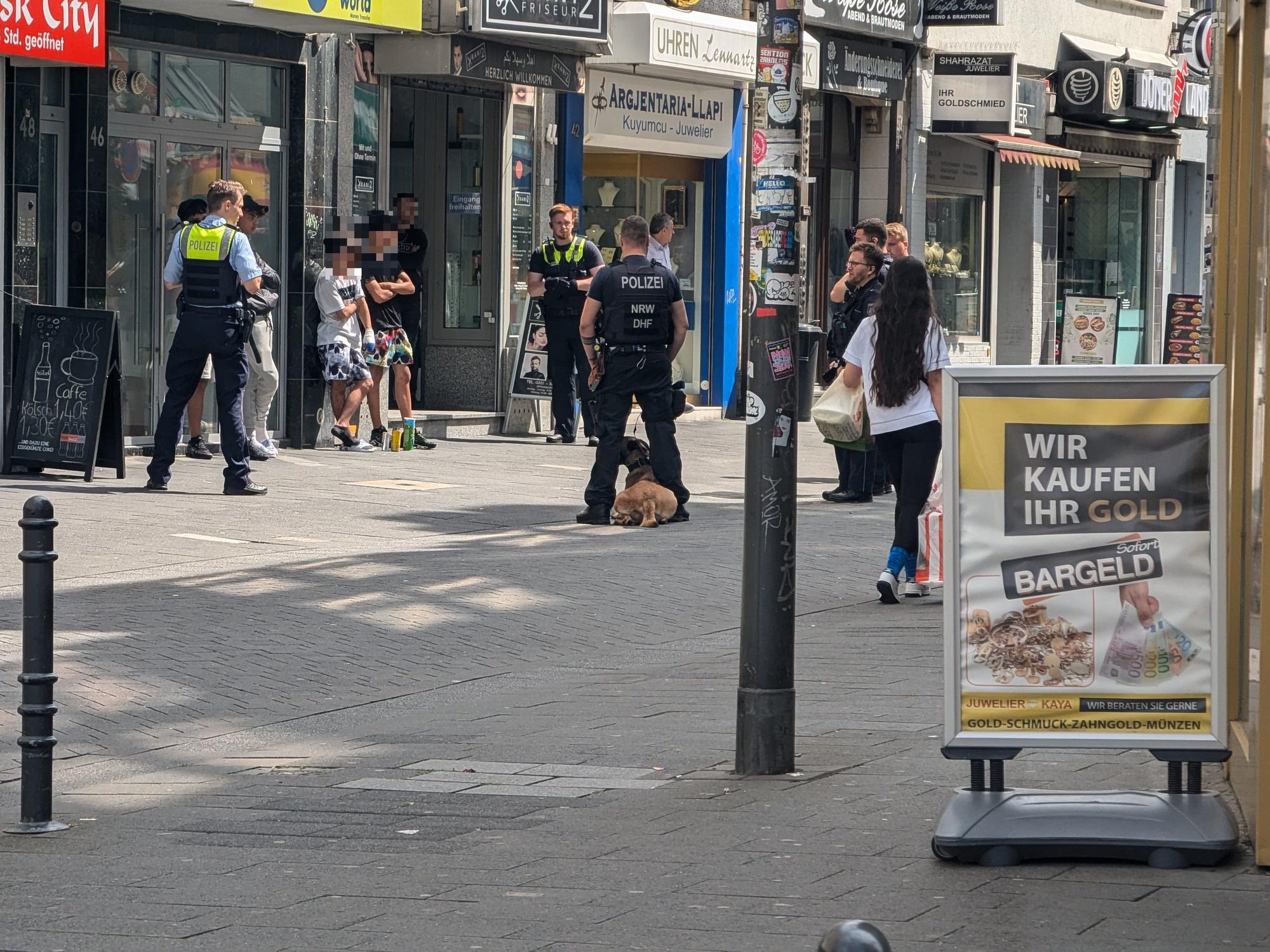 Einsatzkräfte der Polizei stehen um mehrere Verdächtige herum.