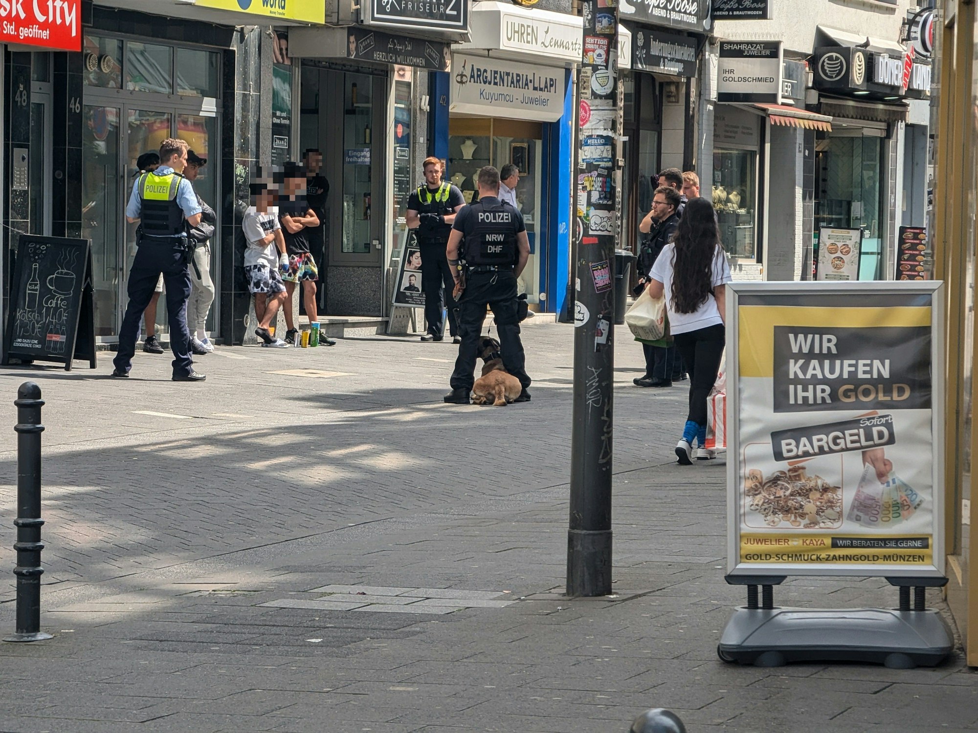 Einsatzkräfte der Polizei stehen um mehreren Verdächtige herum.