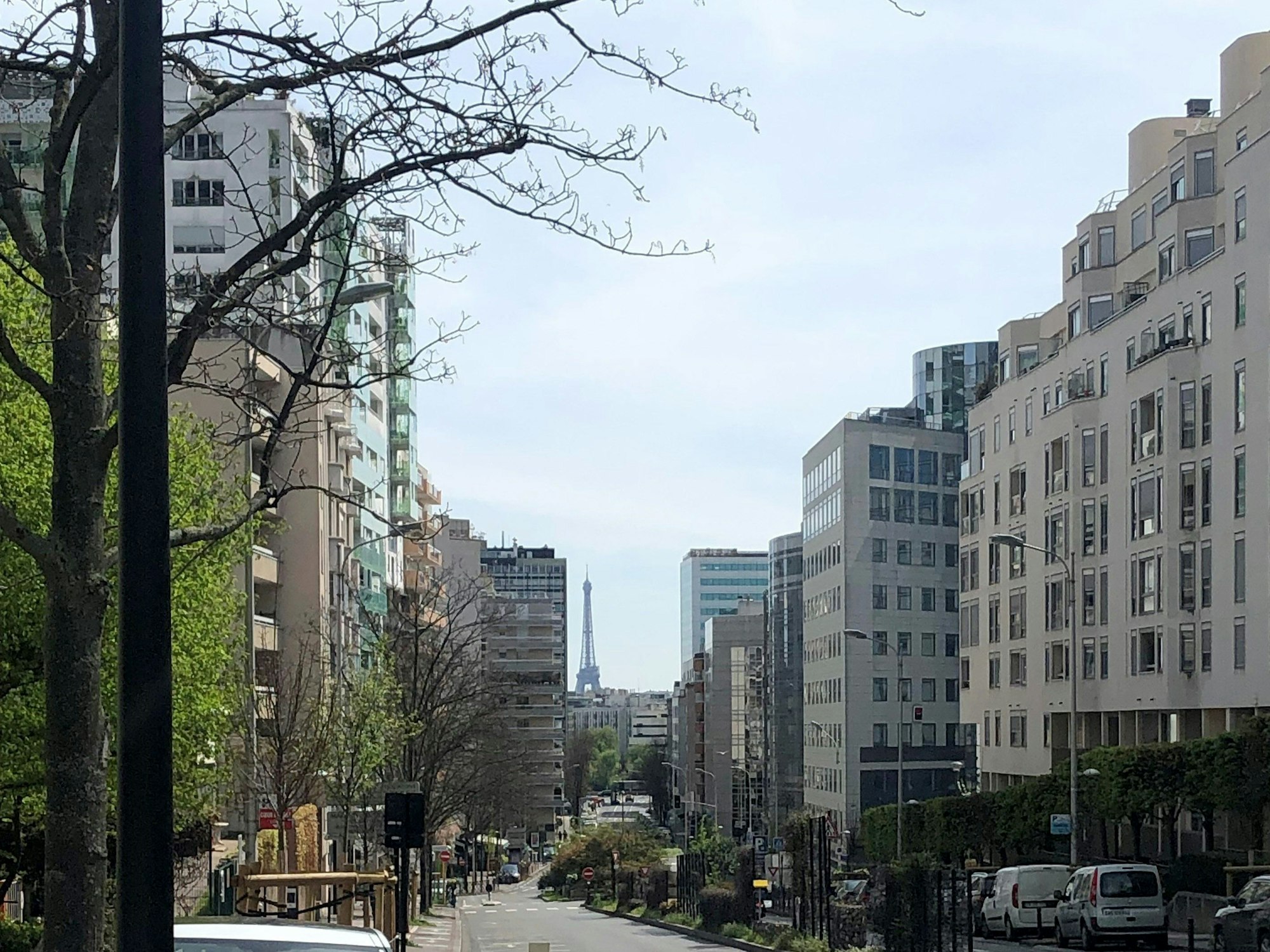 Vor Wohngebäuden am Stadtrand blickt man auf den Eiffelturm.