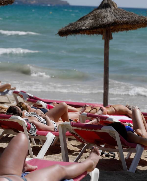 Menschen sonnen sich am Strand von Arenal.