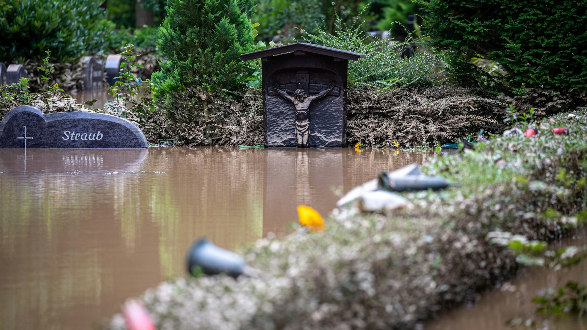 Ein Grabstein ragt bei einem Hochwasser knapp aus dem Wasser heraus.