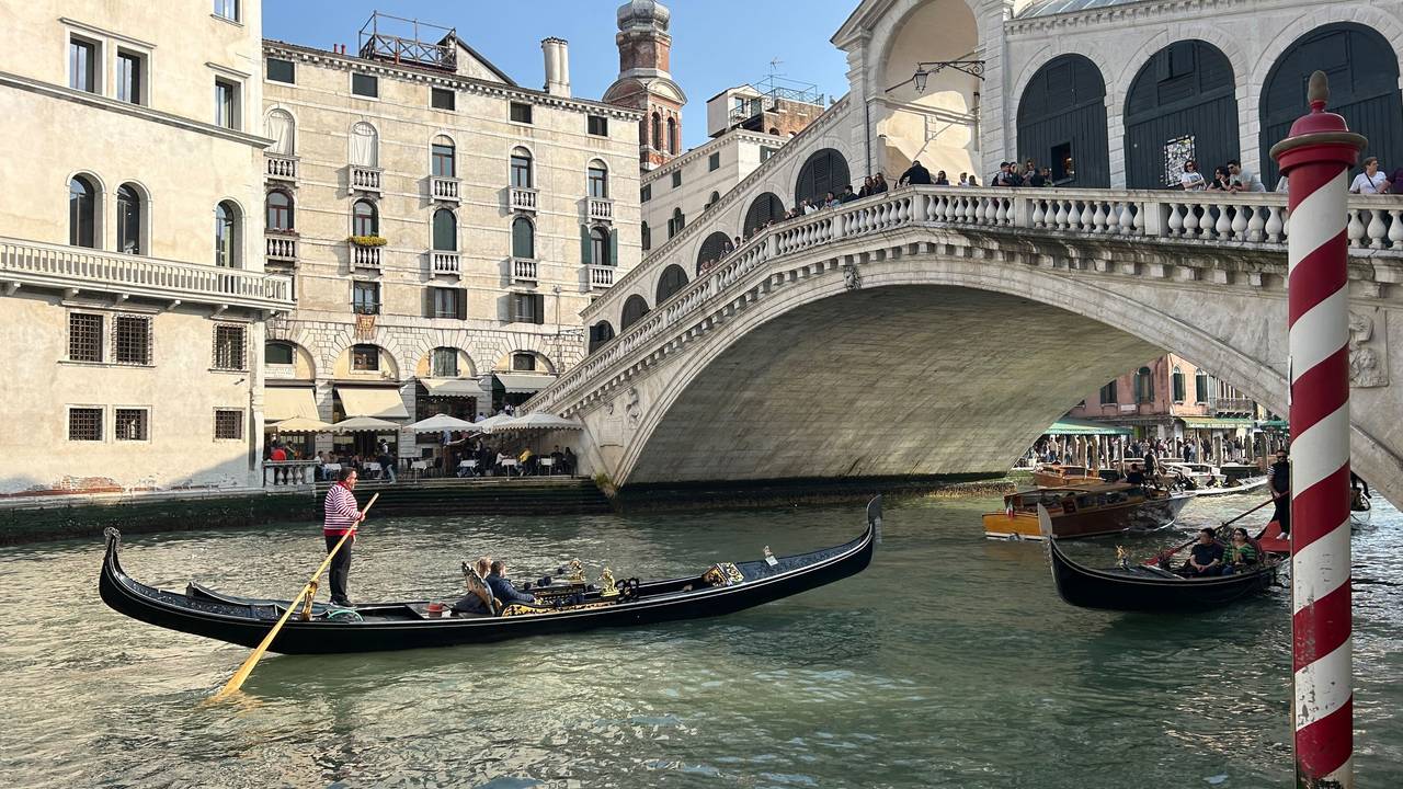 Eine Gondel mit Touris vor der Rialto-Brücke im Zentrum von Venedig.