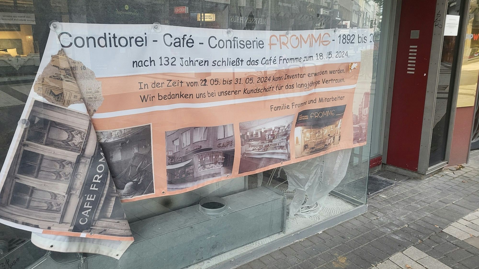 Foto eines Schaufensters, in dem ein altes Plakat hängt.