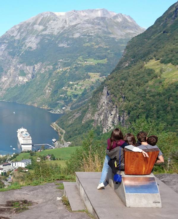 Personenen schauen runter in den Geirangerfjord im Südwesten Norwegens auf die dort liegenden Kreuzfahrtschiffe.