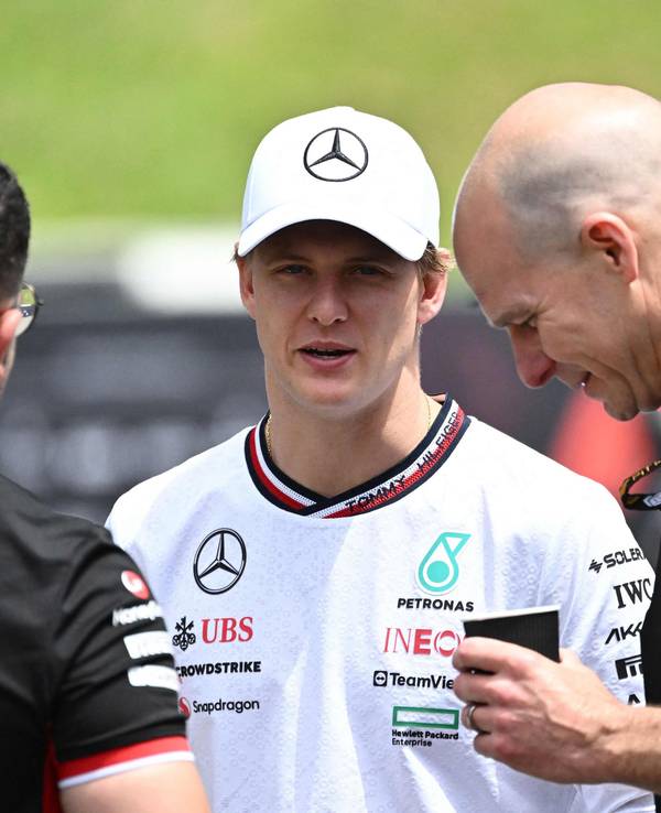 Mick Schumacher unterhält sich mit zwei Haas-Mitarbeitern.
