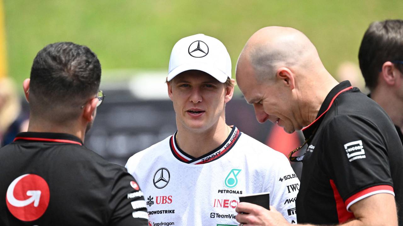Mick Schumacher unterhält sich mit zwei Haas-Mitarbeitern.