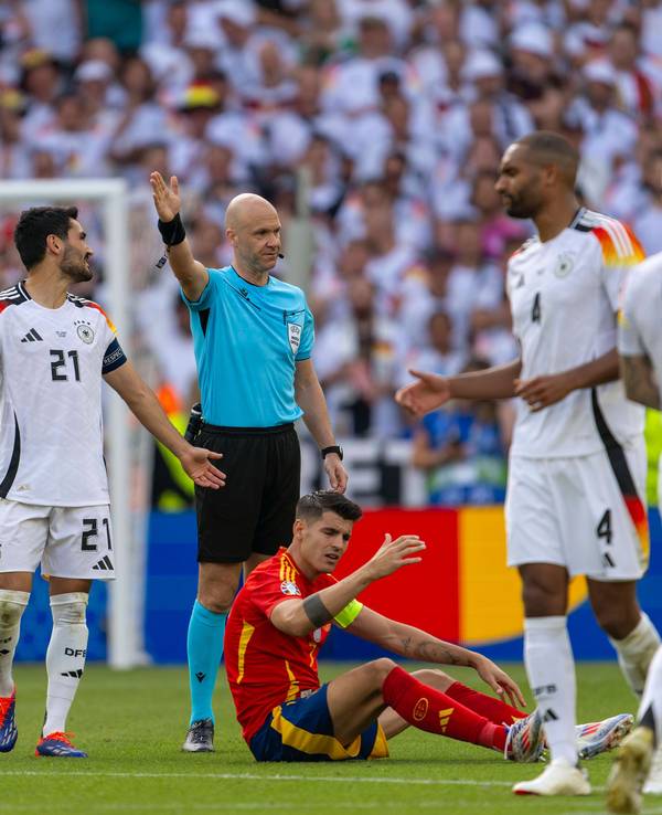 Schiedsrichter Anthony Taylor beim EM-Viertelfinale zwischen Spanien und England, um ihn herum beschweren sich die beiden Kapitäne Ilkay Gündogan (l.) und Álvaro Morata.