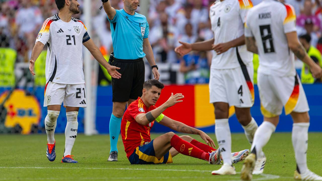 Schiedsrichter Anthony Taylor beim EM-Viertelfinale zwischen Spanien und England, um ihn herum beschweren sich die beiden Kapitäne Ilkay Gündogan (l.) und Álvaro Morata.