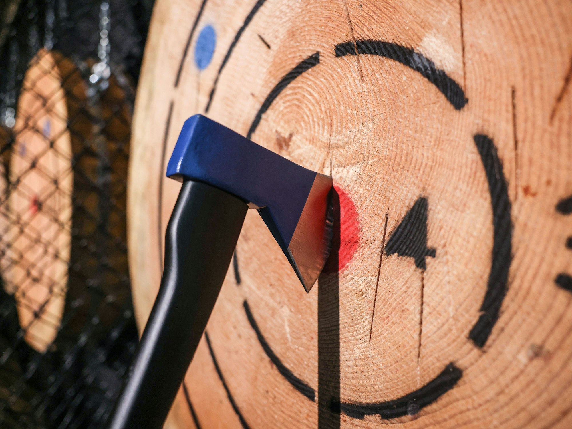 Eine Axt steckt in der Axtwurf-Bar in Köln in einer Holzscheibe.