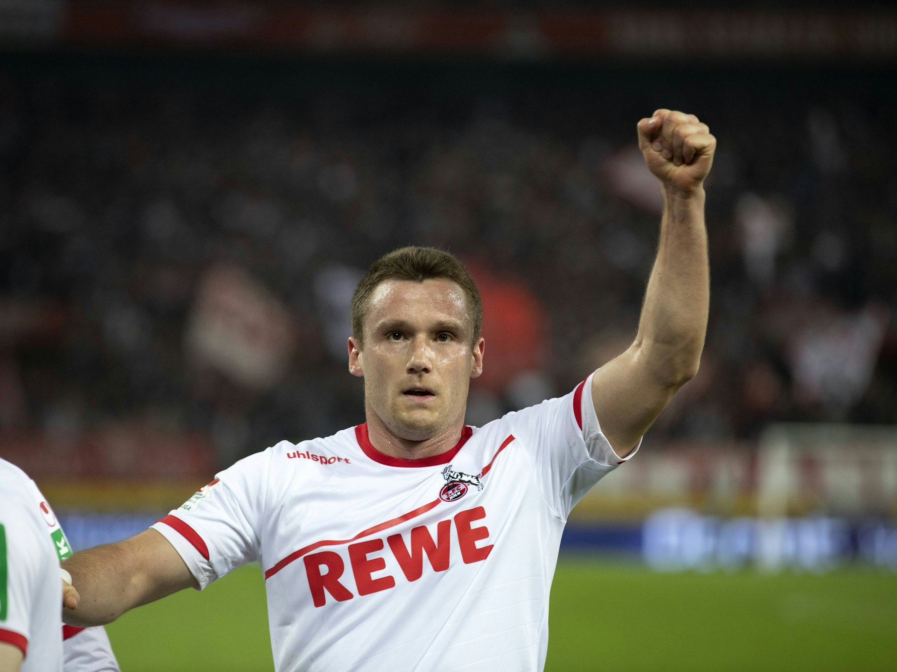 Christian Clemens reckt im FC-Trikot die Faust in den Himmel.