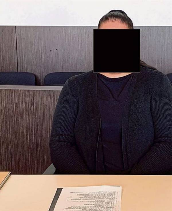 Eine Frau sitzt im Gericht auf der Anklagebank.