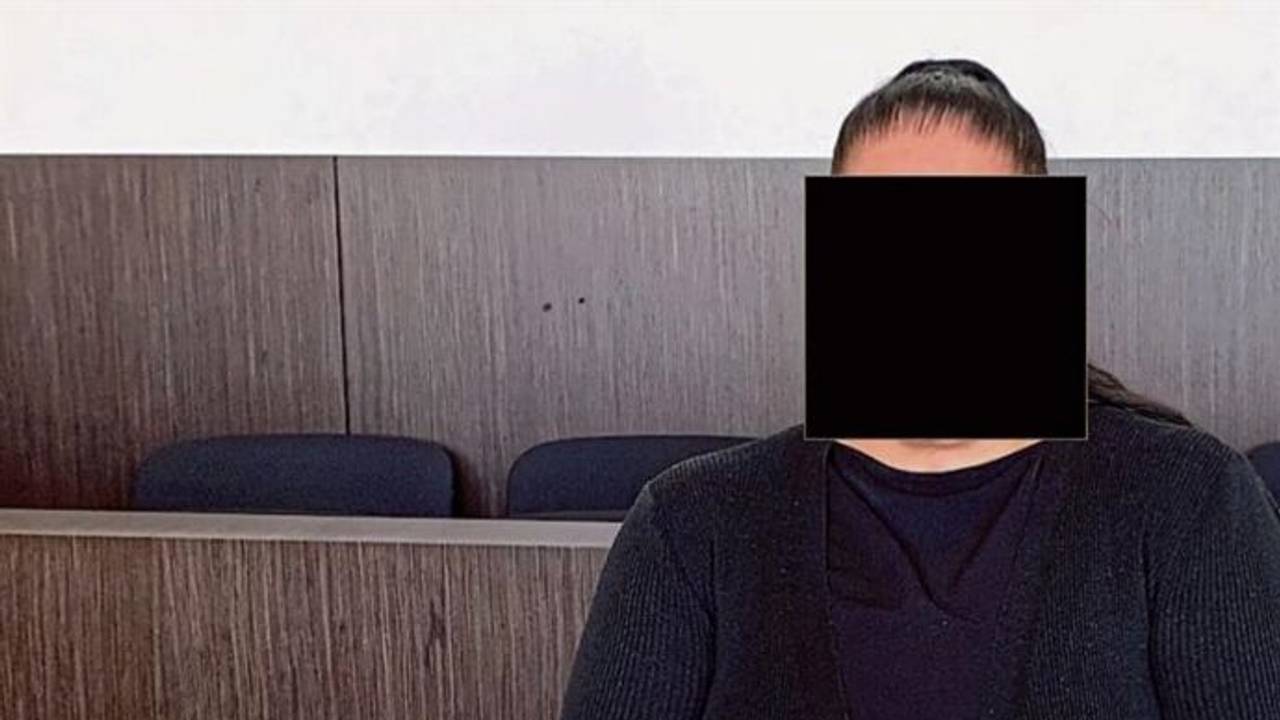 Eine Frau sitzt im Gericht auf der Anklagebank.