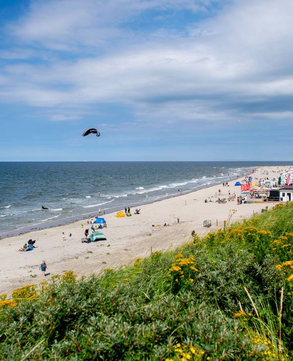 Menschen verbringen ihre Freizeit bei sonnigem Wetter am Strand der Insel Baltrum.