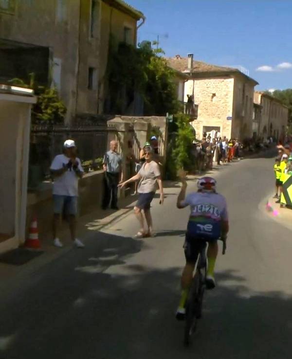 Bei der 16. Etappe der Tour de France quert eine Zuschauerin die Straße, kurz bevor der Führende Thomas Gachignard durch eine Engstelle rast.