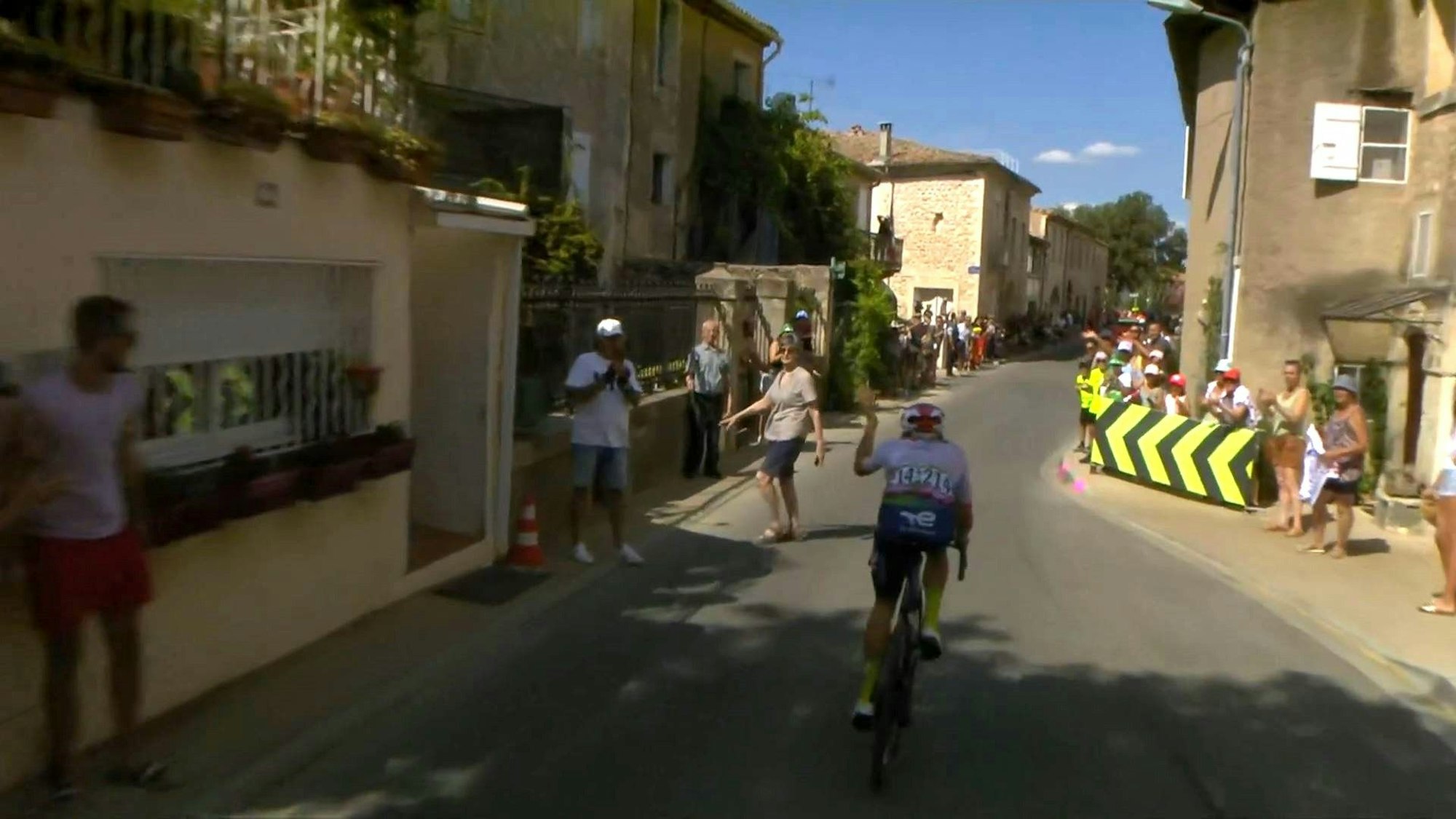 Bei der 16. Etappe der Tour de France quert eine Zuschauerin die Straße, kurz bevor der Führende Thomas Gachignard durch eine Engstelle rast.