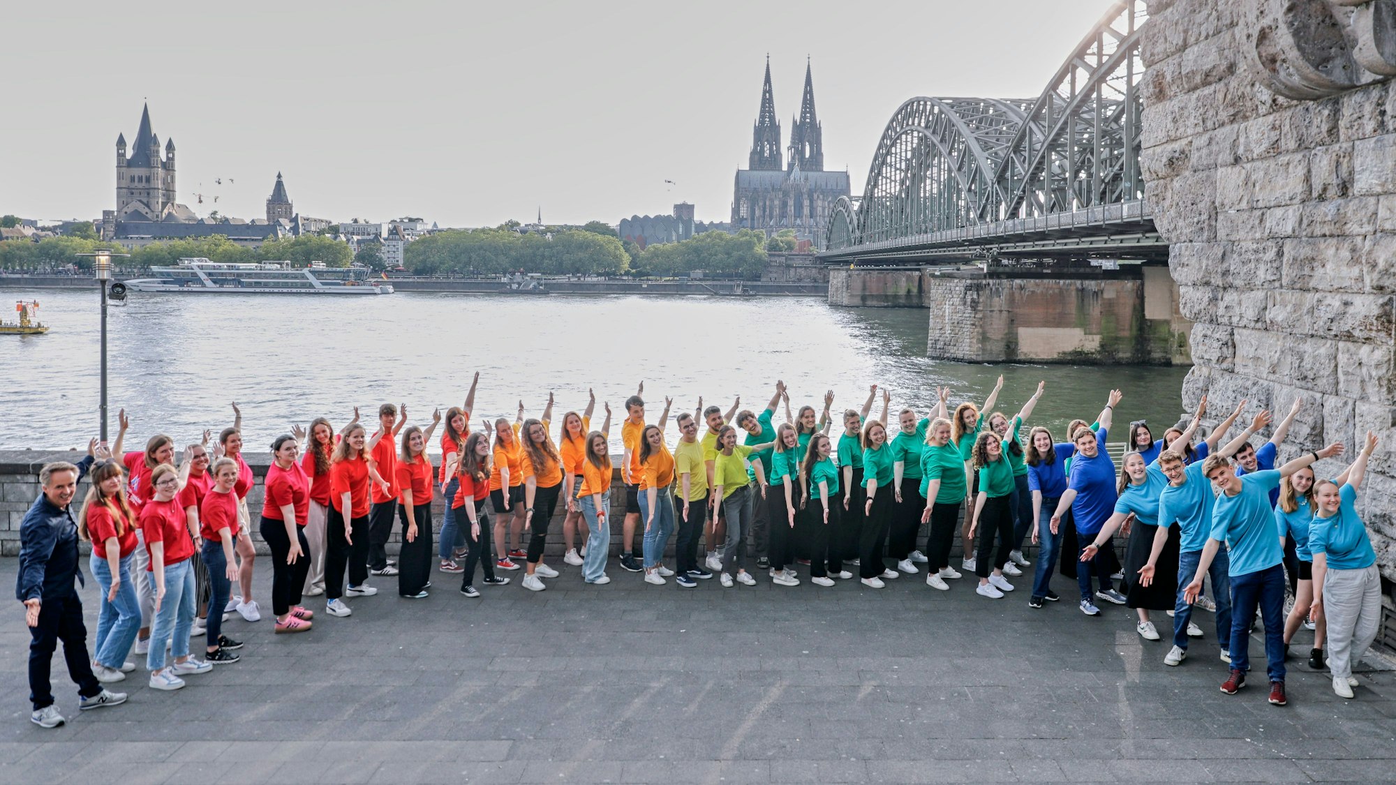 Jugendchor St. Stephan steht am Rheinufer.