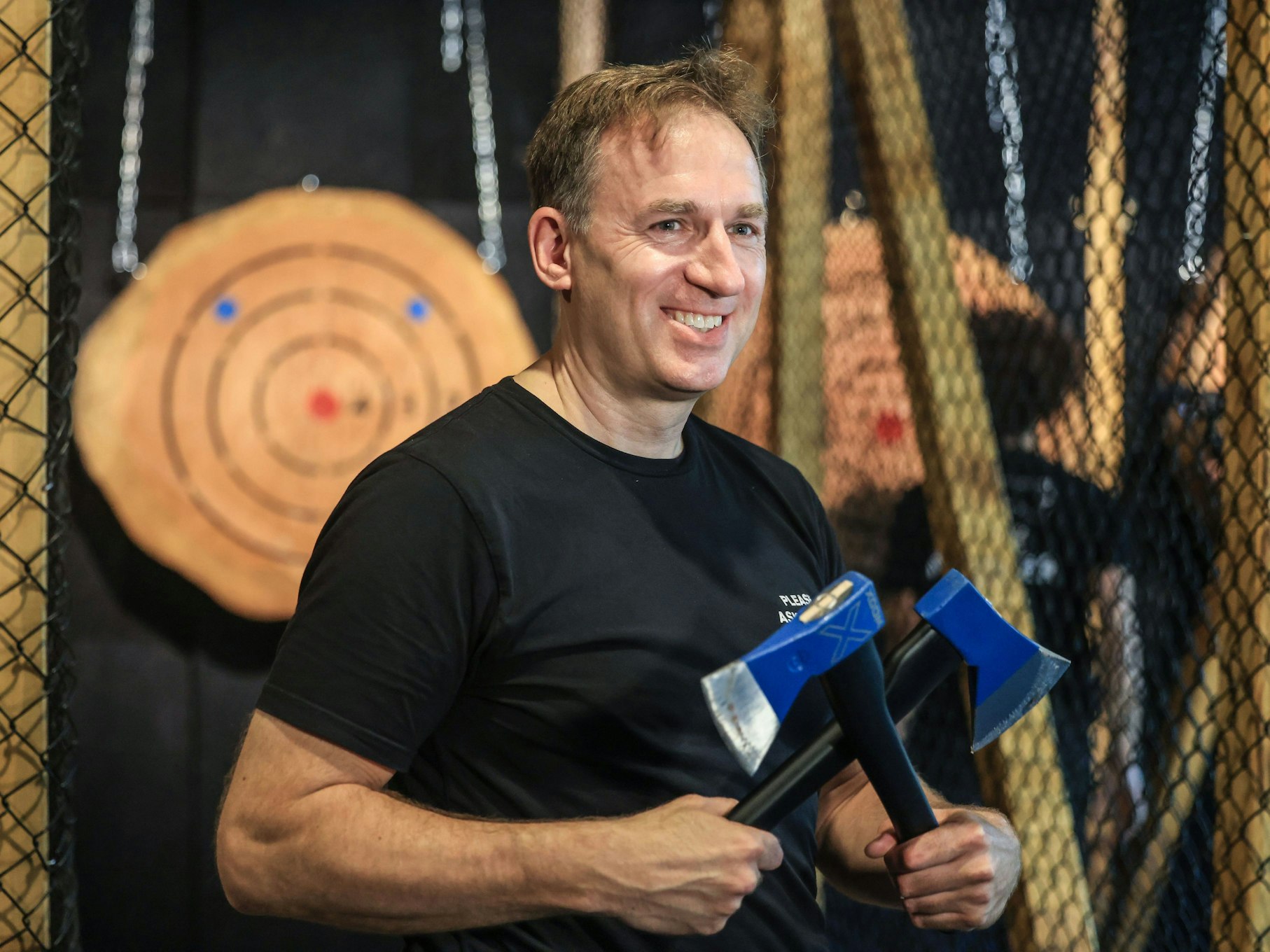 Martin Dencker, Geschäftsführer der Axtwurf-Bar, hält zwei Äxte in der Hand.