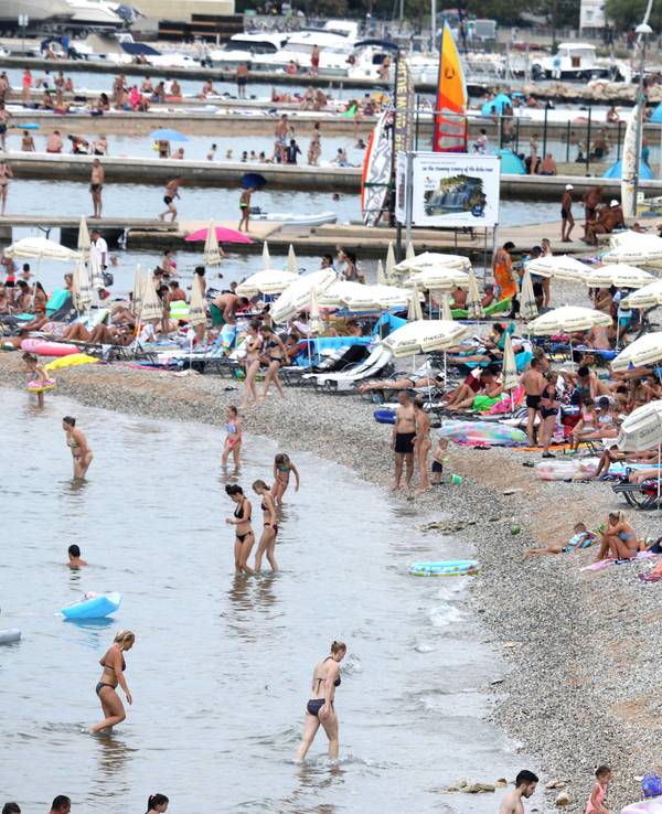 Menschen verbringen im August 2028 Zeit am Strand im kroatischen Vodice.