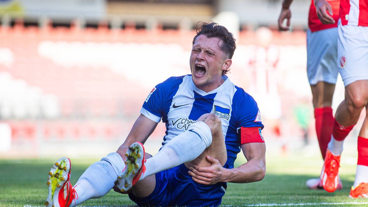 Hertha BSC Kapitän Fabian Reese hält sich mit schmerzverzerrtem Gesicht den Knöchel.