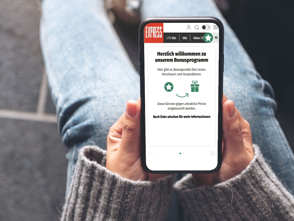 Eine Person hält ein Handy mit dem Bonusprogramm von EXPRESS.de