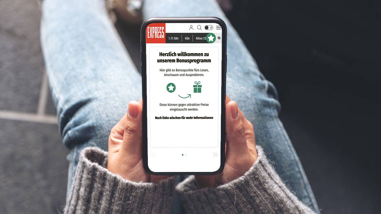 Eine Person hält ein Handy mit dem Bonusprogramm von EXPRESS.de