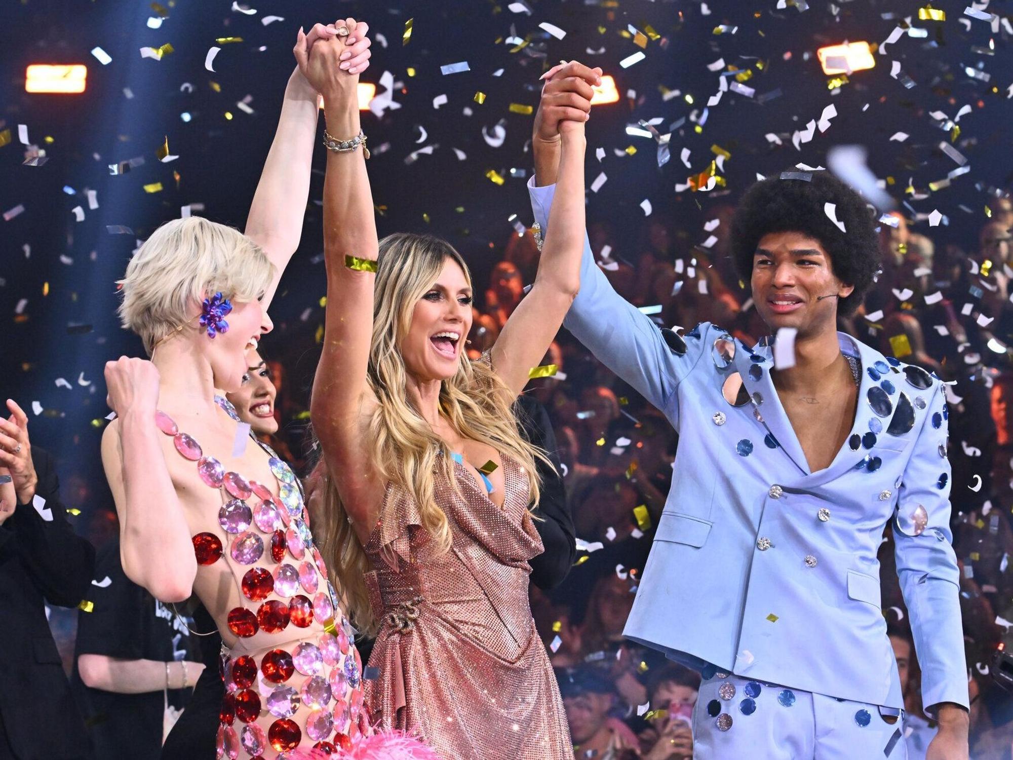 Model Heidi Klum (Mitte) hält die Hände von Lea und Jermaine, den Siegern der 19. Ausgabe von „Germany's Next Topmodel“, hoch. Im Finale setzten sich die beiden Nachwuchsmodels am Donnerstagabend in Köln gegen fünf weitere Kandidatinnen und Kandidaten durch.