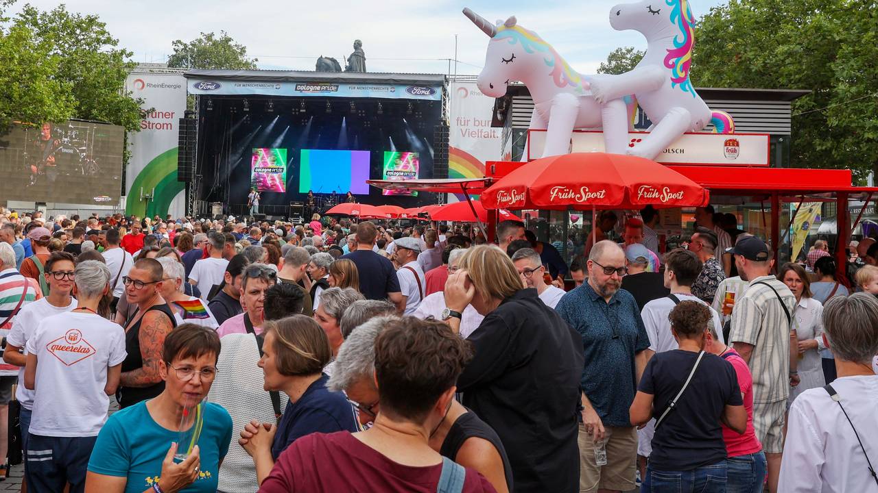 Menschen stehen vor einer Bühne.