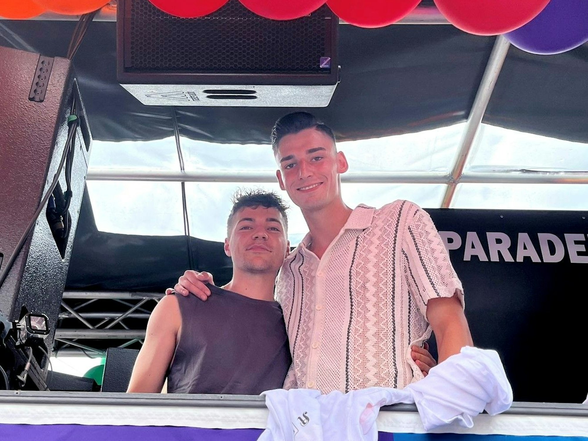 Zwei Männer stehen auf einem Wagen und umarmen sich.