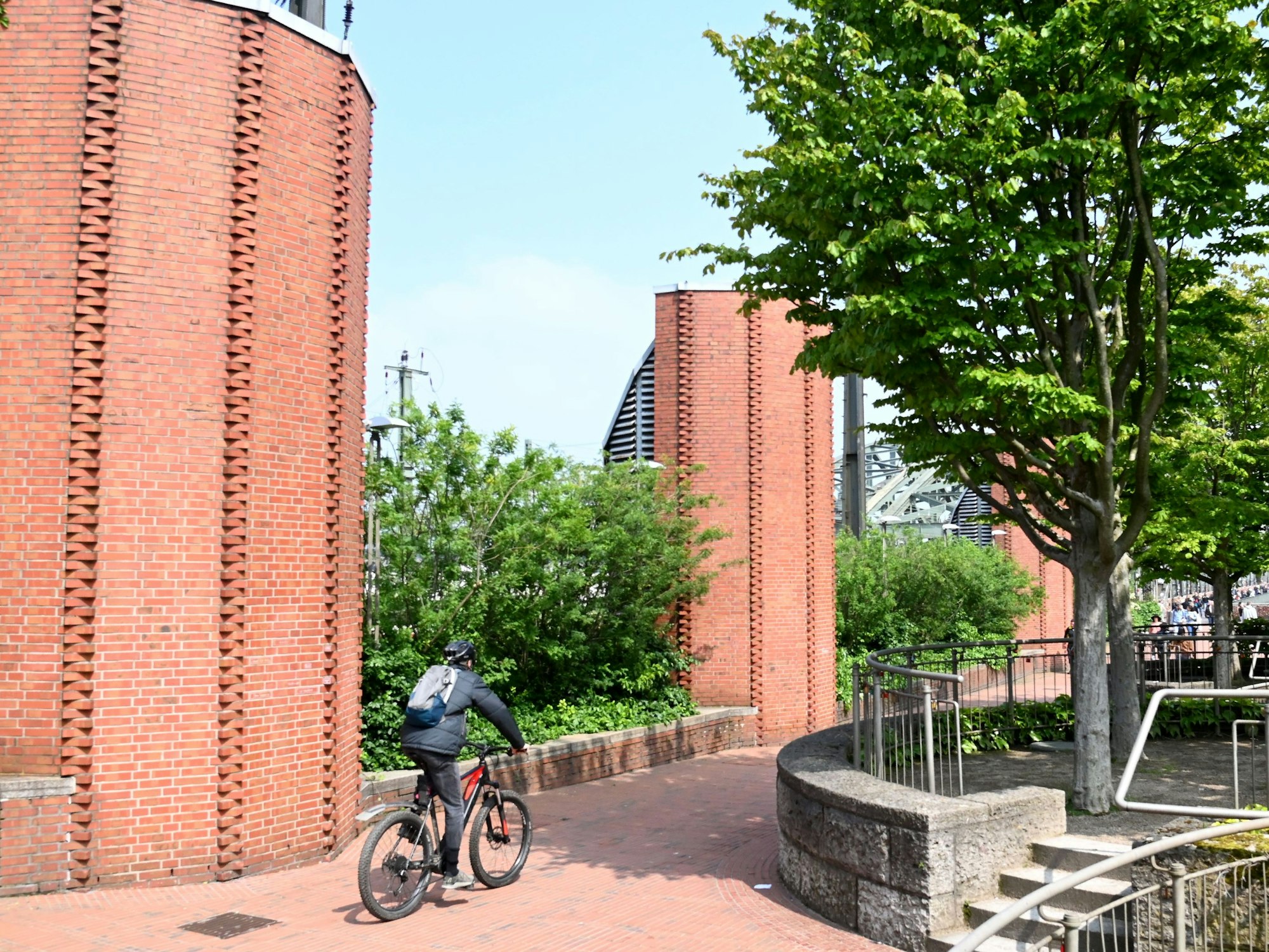 Ein Mann fährt mit einem Fahrrad auf eine Brücke zu.