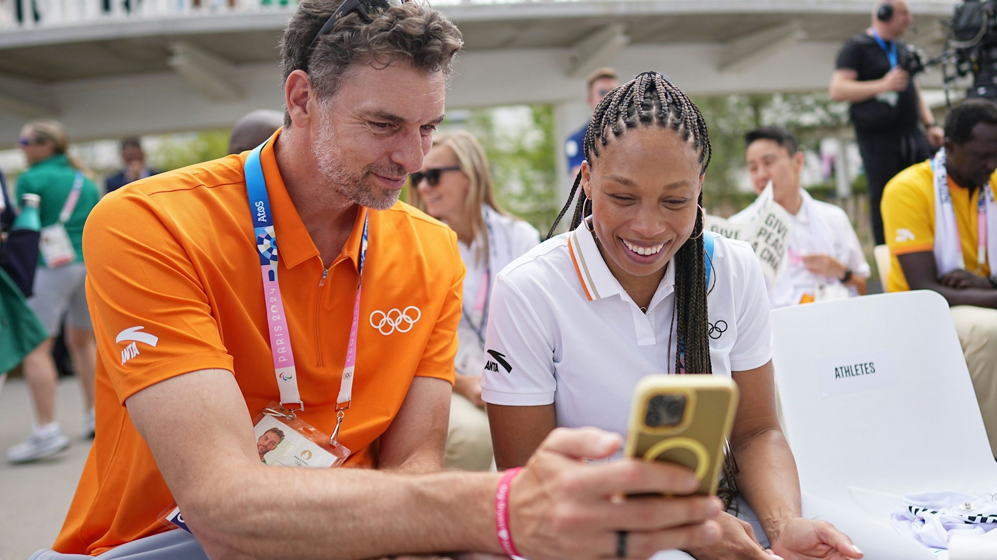 Allyson Felix und Pau Gasol schauen auf ein Smartphone.
