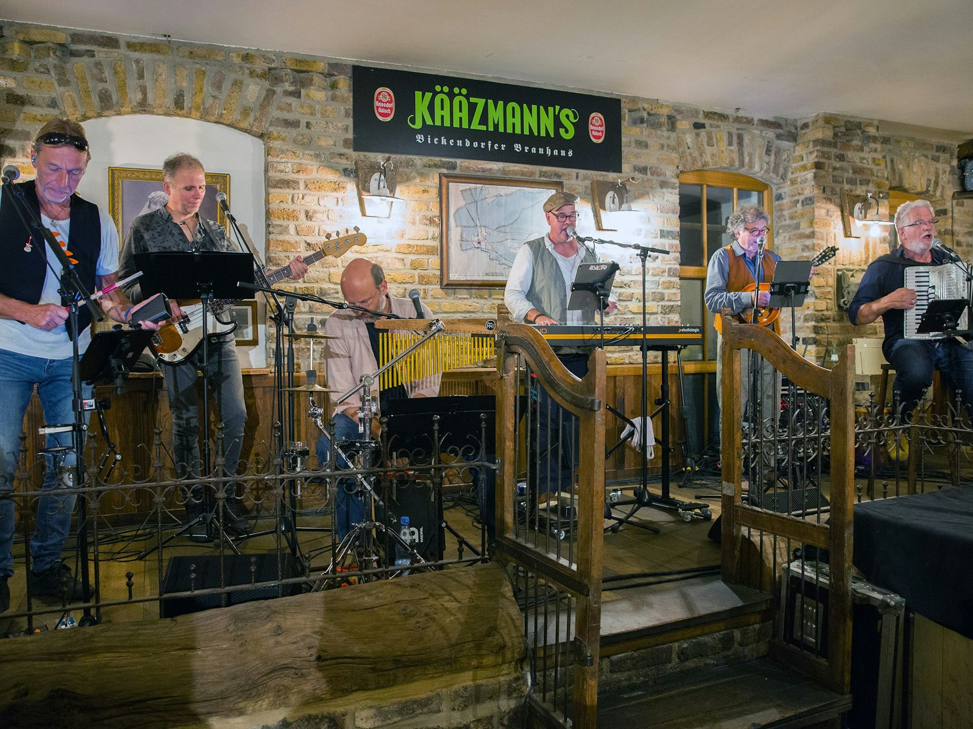 Eine Band steht auf einer Bühne in einer Gaststätte.