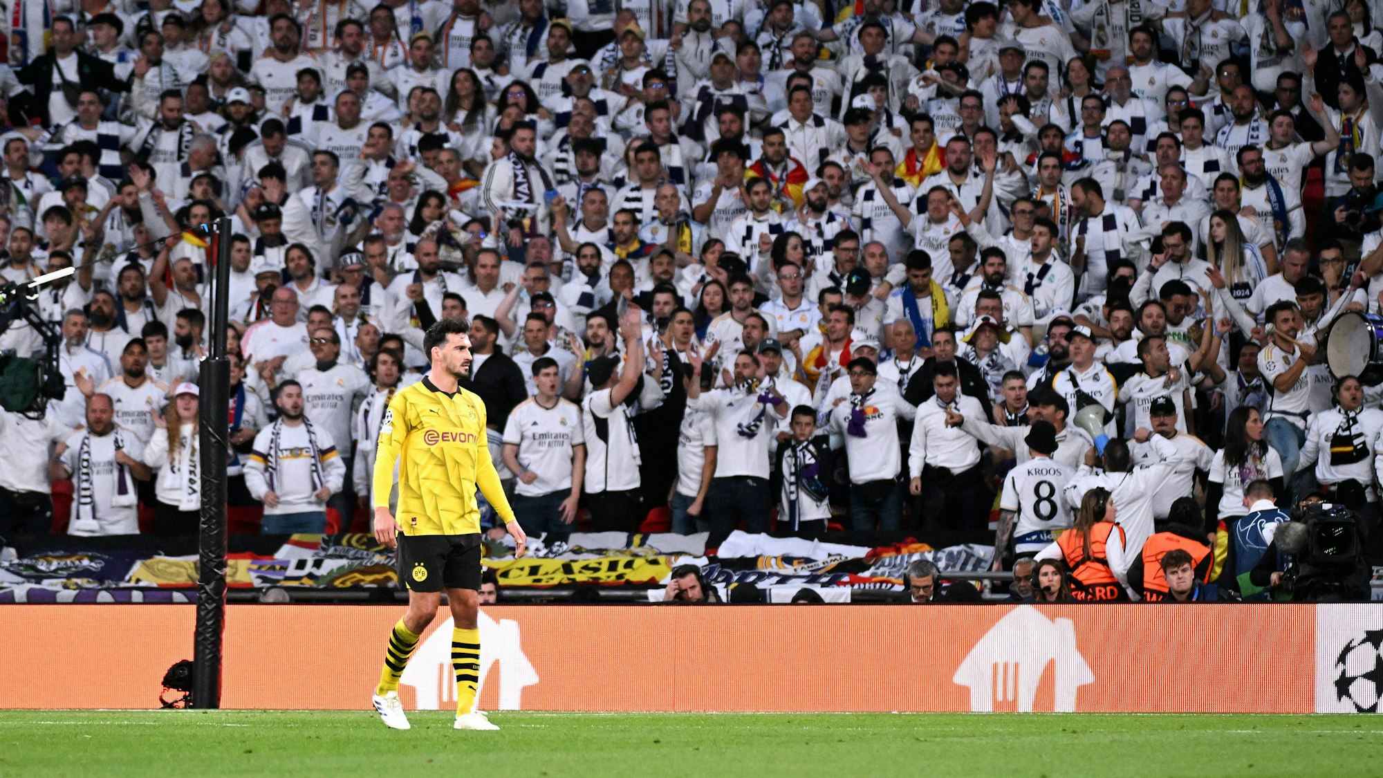 Mats Hummels steht auf dem Rasen vor Fans von Real Madrid.